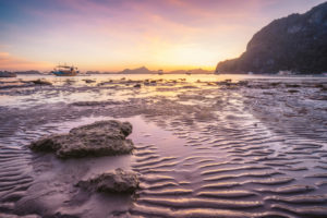 Corong beach, El Nido, Philippines. Sunset on tropical beach. Sun reflections at the golden hour. mountain chain islands at horizon. Corong beach, El Nido, Philippines. Sunset on tropical beach. Sun reflections at the golden hour. mountain chain islands at horizon.